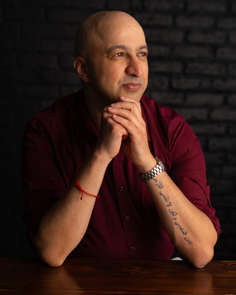 Hicham Souilmi, SEO and AI search consultant, in a thoughtful pose at a wooden table